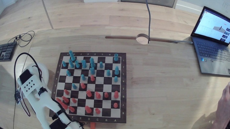 Raw overhead frame: the board on a desk, with a laptop, cables and my hands in shot